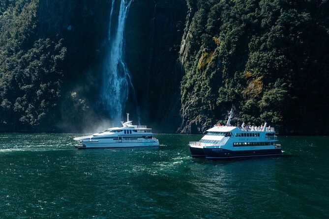 Two boats in front of a waterfall, the spray rising beside them