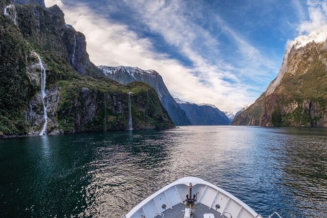 The view from the bow down the fiord, two waterfalls falling from the left-hand wall