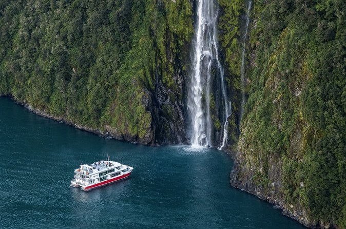 Looking down on a waterfall and a cruise boat from the air